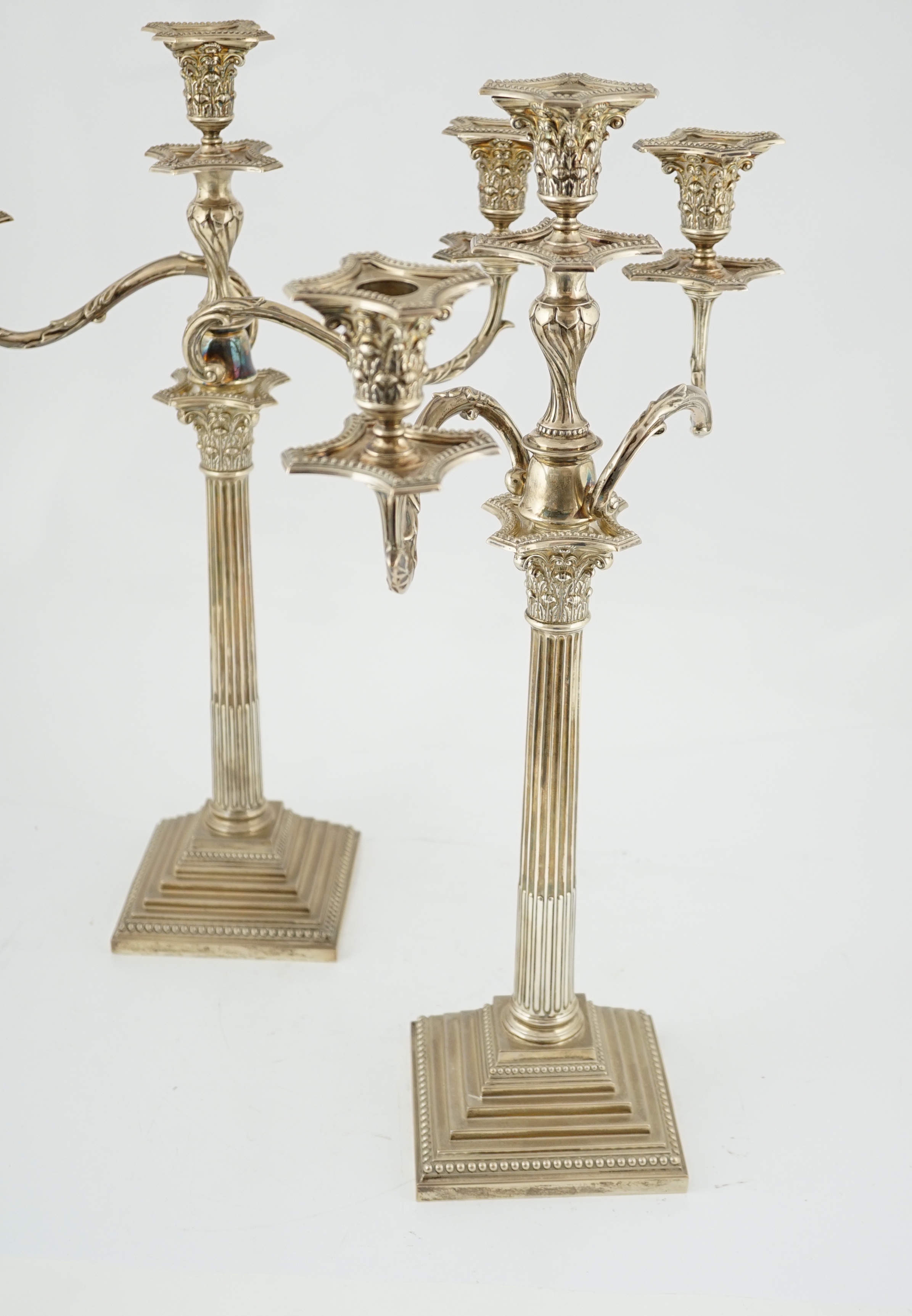 A pair of Edwardian silver two branch, three light Corinthian column candelabra, by William Hutton & Sons